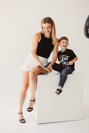 A joyful moment captures a mother and son in a bright studio, showcasing their loving bond through heartfelt smiles and laughter, creating a heartwarming sceneの写真素材