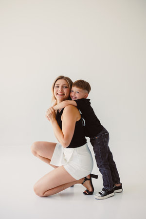 A heartfelt moment in a cozy studio captures a mothers love and playful interaction with her son, highlighting their joyful bond filled with warmth and happinessの写真素材