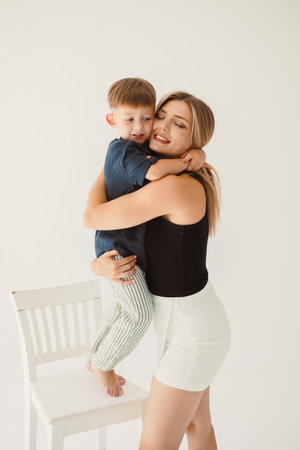 A cheerful parentchild interaction is captured in a bright studio, showcasing their love during a playful embrace, ideal for familythemed projects celebrating joyの写真素材