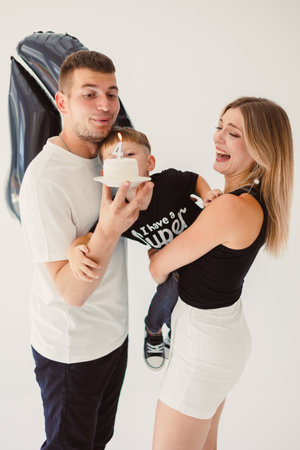 A warm and loving family comes together to celebrate a special occasion, such as a birthday, with a joyful child, a colorful cake, bright smiles, and laughter echoing all aroundの写真素材