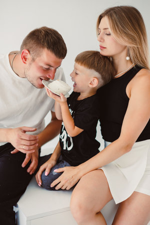 A heartwarming scene unfolds as a young family spends precious time together, with their child joyfully interacting with loving parents, showcasing their strong bondの写真素材