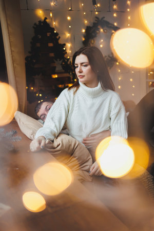 Cute girl in New Year's locations in a cozy living room. Woman at home for the new year.の写真素材