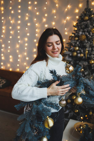 Cute girl in New Year's locations in a cozy living room. Woman at home for the new year.の写真素材
