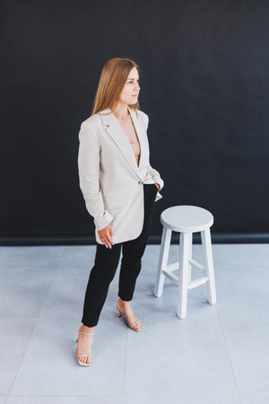 A confident model elegantly showcases a chic beige blazer paired with sleek black pants, creating an inspiring outfit that resonates with and captivates fashion lovers everywhereの写真素材