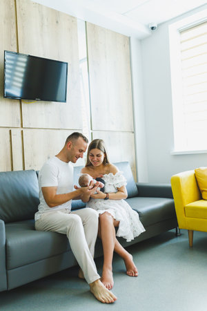 A loving couple in a cozy and inviting space shares cherished and precious moments with their newborn baby, creating joyful and unforgettable memories to hold dear foreverの写真素材