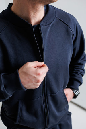 A stylish man sporting a navy zipup jacket, seamlessly blending comfort and contemporary fashion in modern athletic wear that is perfect for casual outings as well as workoutsの写真素材