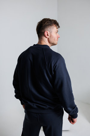 This contemporary navy blue sweater designed specifically for men boasts a relaxed fit and a stylish silhouette, making it perfect for casual outings and ensuring allday comfortの写真素材