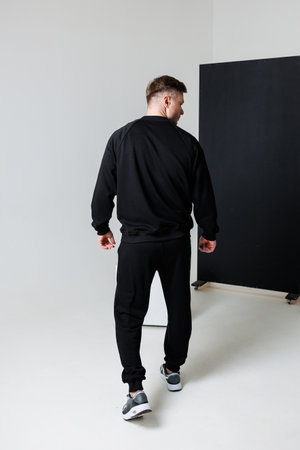 This trendy and fashionable black sportswear outfit consists of a stylish sweatshirt and matching pants, making it perfect for casual urban environments or intense workoutsの写真素材