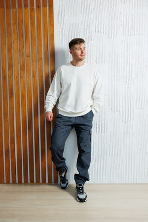 A stylish young man confidently displays a relaxed outfit in a vibrant setting, showcasing contrasting textures and colors that highlight his unique personalityの写真素材