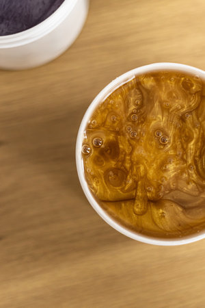This closeup photo showcases an enticing creamy mixture presented in a sleek white container,...