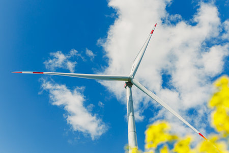 Ecological energy generation by windmills from the wind. Windmill field. Wind turbines generating energy against a clear blue sky. Wind turbines generating clean renewable energy in a rural field.の写真素材