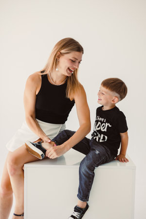 Mom and 4 year old son smiling and hugging on a white background. Warm relationship between mom and son. Concept of family relationships between mom and son.の写真素材