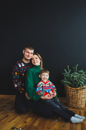 A joyful family portrait features loving parents and their adorable child in colorful Christmas...