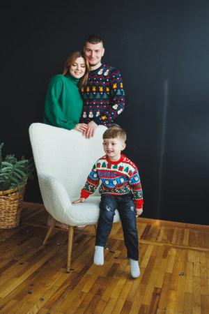 A vibrant family in colorful holiday sweaters poses together, joyfully embodying the warmth and spirit of the festive season with a stylish and cozy atmosphereの写真素材