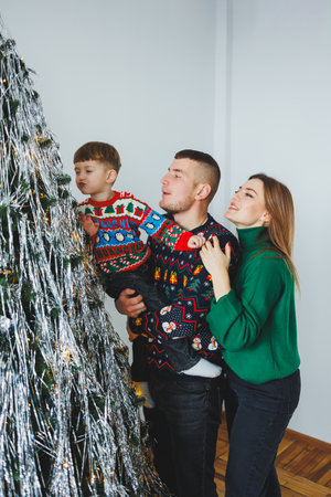 A lively and joyful family gathers around their beautifully decorated Christmas tree, embracing the warmth of the holiday spirit and the treasured feeling of togethernessの写真素材