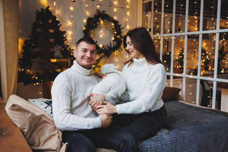A joyful family captures a heartwarming moment by the fireplace, adorned with twinkling lights and festive decor, showcasing love and warmth during the holiday season.の写真素材