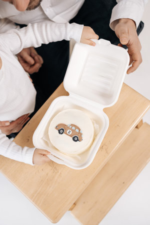 Small bento cake. with a car. Sweet mini cake for the birthday boy. Glazed cake in a box.