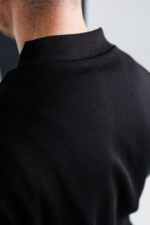 This is a detailed and closeup view of a mens black sports top that showcases intricate and stylish stitching along the back, making it ideal for activewear fashion showcasesの写真素材