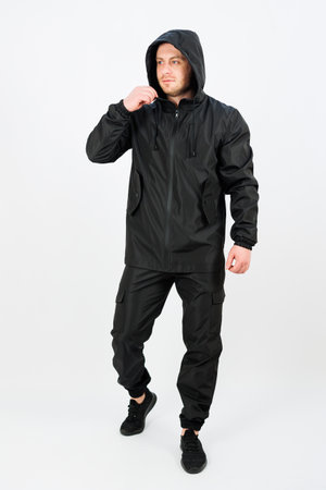 This stylish and fashionable black waterproof jacket and pants set is expertly designed for maximum comfort and exceptional durability during outdoor activities or casual outingsの写真素材