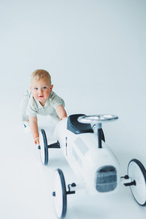 A little one-year-old boy in a t-shirt runs and laughs around the room. A toddler boy is happy and smiling.の写真素材