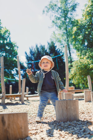 Toddler running and playing on the playground. 2 year old boy on green grass in the park, enjoying a sunny summer day. Activities for children in nature.の写真素材