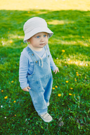 Cute boy running on the grass. Carefree childhood with joyful laughter of a child. Toddler having fun and enjoying a walk in nature.の写真素材