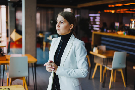 In a contemporary, modern office, a poised businesswoman stands confidently, exuding professionalism and determination as she prepares for her next significant challenge aheadの写真素材
