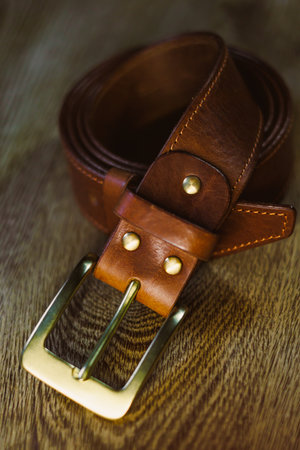 This exquisitely crafted brown leather belt showcases a stunning, classic golden buckle. It serves as the perfect accessory for elevating both style and function in any wardrobeの写真素材