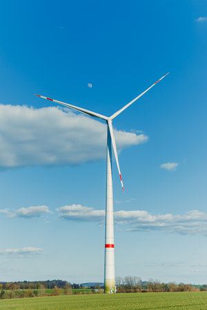 A field of wind turbines generating energy standing in a green field. Wind turbines in a yellow field somewhere in the countryside in Europe.の写真素材