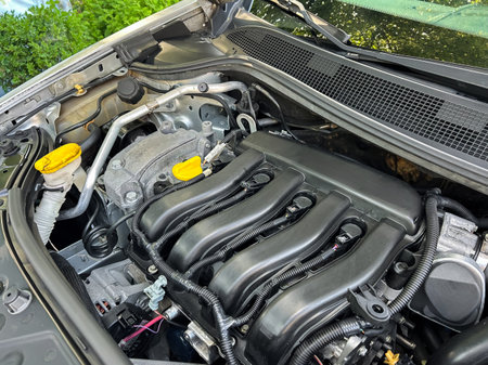 A close-up shot of a high-performance car engine, featuring a sleek black intake manifold, vibrant yellow caps, and various components showcasing advanced engineering.の写真素材