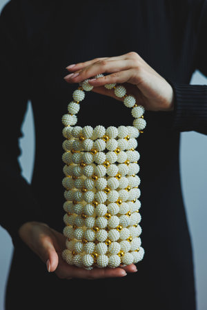 This exquisite handbag, adorned with stunning pearl embellishments and showcasing a unique design, is truly perfect for elevating any outfit and is ideal for fashionable occasionsの写真素材