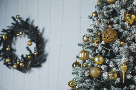 A stunning Christmas tree adorned with shiny golden ornaments and a stylish wreath, serving as an inspiring centerpiece for holiday projects and seasonal decor ideasの写真素材