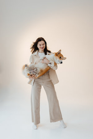Young woman playing with her corgi dog. Healthy lifestyle and living in an apartment with a pet....