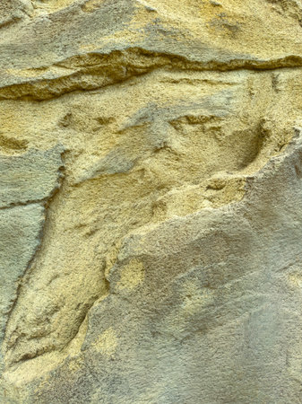 A closeup of an abstract rock surface with unique textures and golden highlights, perfect for...