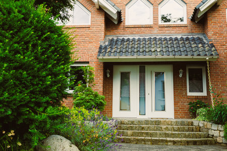 This beautifully designed brick house features an inviting entrance, enhanced by vibrant gardens and...