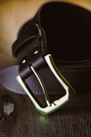 This closeup photo showcases a beautifully designed leather belt with a shiny buckle, perfect for...
