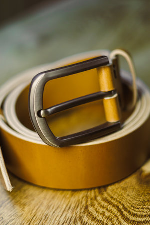 This stylish tan leather belt, featuring a sturdy metal buckle, serves as a perfect accessory and adds an elegant touch to both casual and formal outfits, ensuring versatilityの写真素材