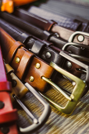 This captivating arrangement of assorted leather belts showcases diverse colors and unique buckle designs, perfect for fashion inspiration and trendy accessoriesの写真素材