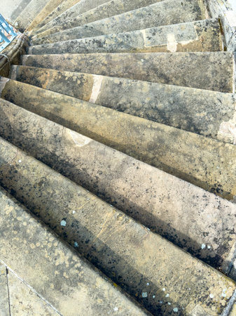 Aerial views reveal a beautifully aged stone spiral staircase. Its worn steps feature natural textures and moss, enhancing the charm of this unique architectural detailの写真素材