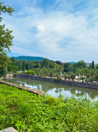Picture a serene river flowing through a lush landscape with rich greenery and mountains under a clear blue sky. Its perfect for nature lovers seeking an escapeの写真素材
