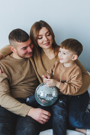 A joyful family shares a moment, depicting their bond as happy parents play with their delighted...