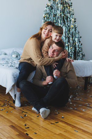 A joyful family embodies the spirit of winter festivities, gathered in a warm atmosphere with decorations, creating lasting holiday projects that bring everyone closerの写真素材