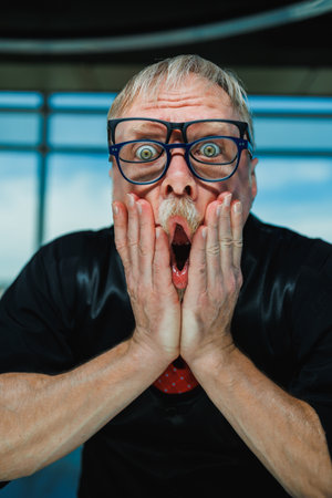 A shocked man with glasses captures a humorous moment, perfect for creative projects needing exaggerated emotions to enhance engagement and vibrancy in scenes or narrativesの写真素材