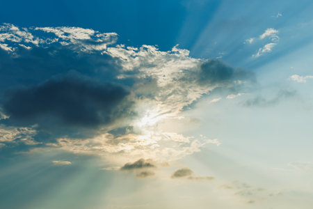 Soft clouds scatter across the sky as warm sunlight streams through, creating a serene scene at...