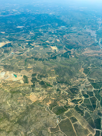 From high above, lush green vineyards, golden fields, and olive groves stretch across the landscape,...