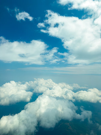 Vast blue sky stretches overhead filled with fluffy white clouds, creating a serene and calming...