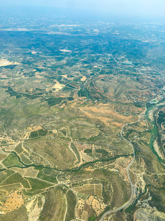 From an aerial perspective, the landscape reveals winding roads and neatly arranged vineyards...