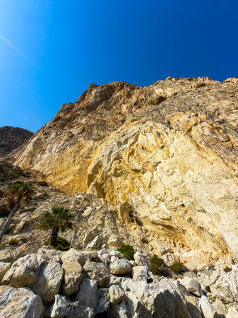 Serene and majestic, the towering cliffs rise sharply against the vibrant blue sky. Sunlight enhances the warm colors of the rock formations. Nature's artistry on full display.の写真素材