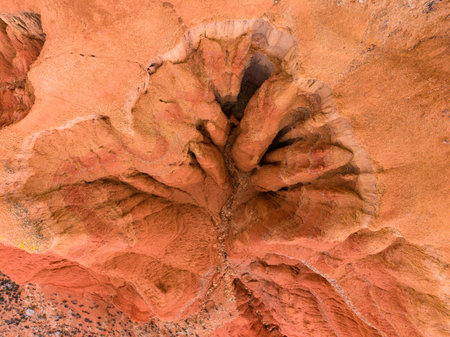 The view shows a large canyon with distinct rock shapes and lines. Bright sunlight strikes the surface, highlighting various shades of orange and brown in the canyon landscape during midday.の写真素材