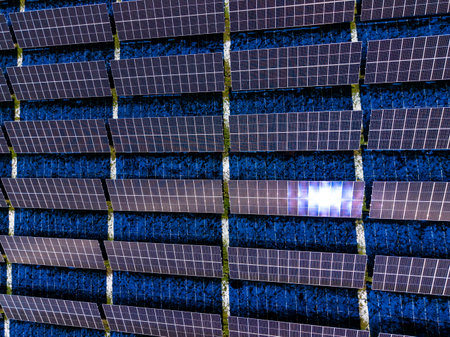Rows of solar panels are set up in a solar farm. The panels are facing upward to capture sunlight....